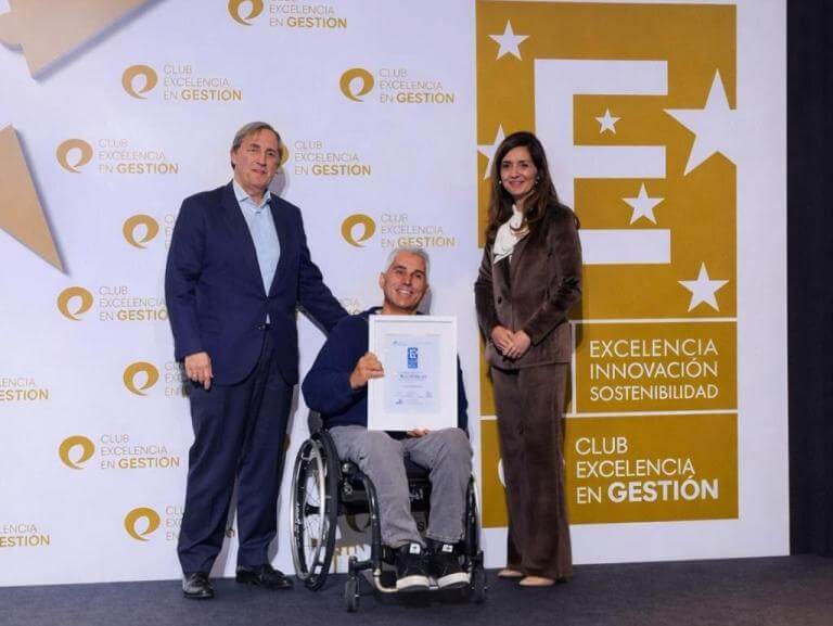 Albert Carbonell, president d'ECOM, recollint a l'escenari el Segell EFQM 400, acompanyat per dues persones representants del Club de Excelencia en Gestión. 