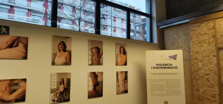 Exposició Dones diverses instal·lada en una sala, on es veuen diverses fotografies exposades i un plafó informatiu