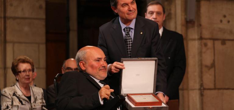 Imatge d'un dels presidents d'ECOM recollint la Creu de Sant Jordi de mans del qui va ser president de la Generalitat de Catalunya,Artur Mas