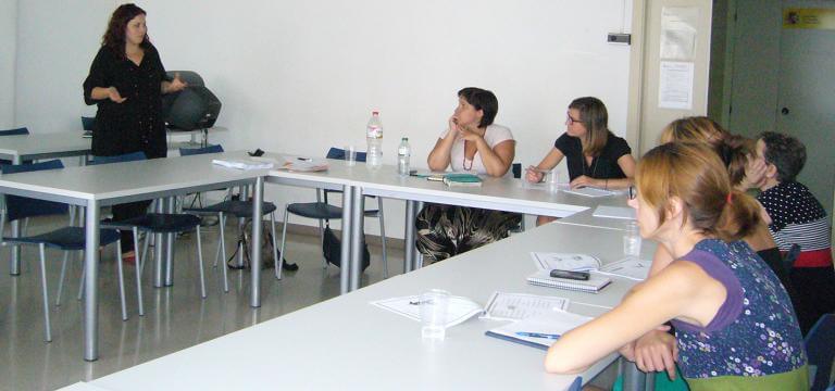 Una aula con diversas personas atendiendo las explicacions de la persona que imparte la formación