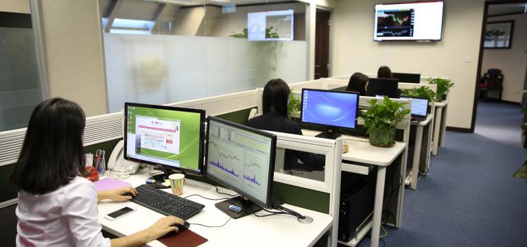 Imatge d'una oficina on hi ha diverses persones treballant amb ordinadors